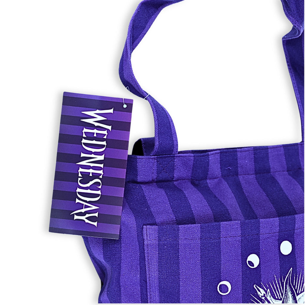 Bolso tote oficial Wednesday detalle etiqueta frontal con logo de la serie en tipografía gótica
