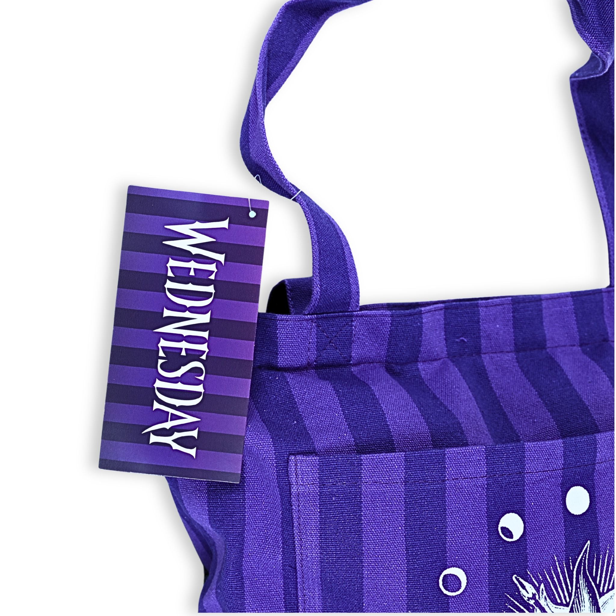 Bolso tote oficial Wednesday detalle etiqueta frontal con logo de la serie en tipografía gótica
