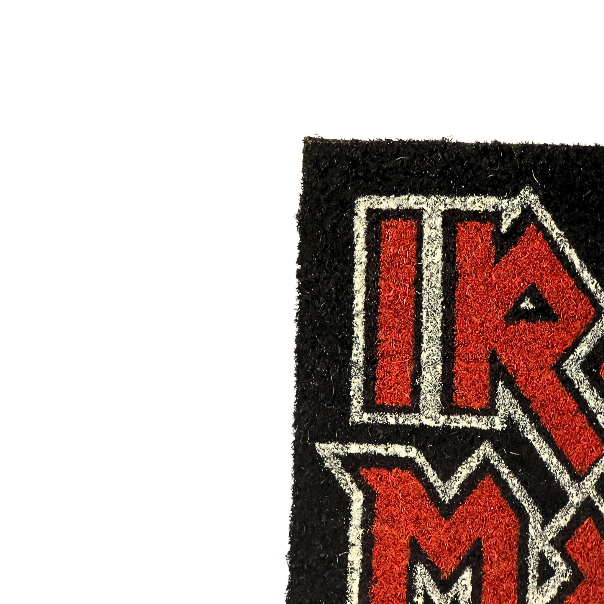 Detalle textura fibra de coco del felpudo Iron Maiden – esquina superior izquierda con logo
